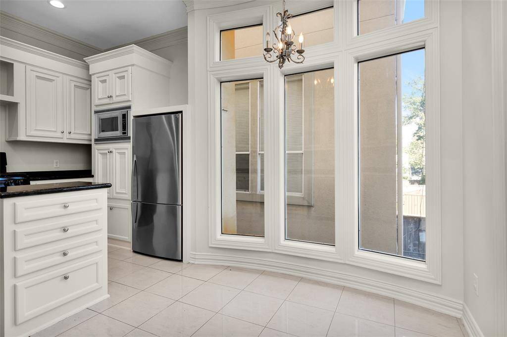 Island Kitchen with Granite Surfaces, Glass Front Cabinets, Wine Frig and Refigerator.