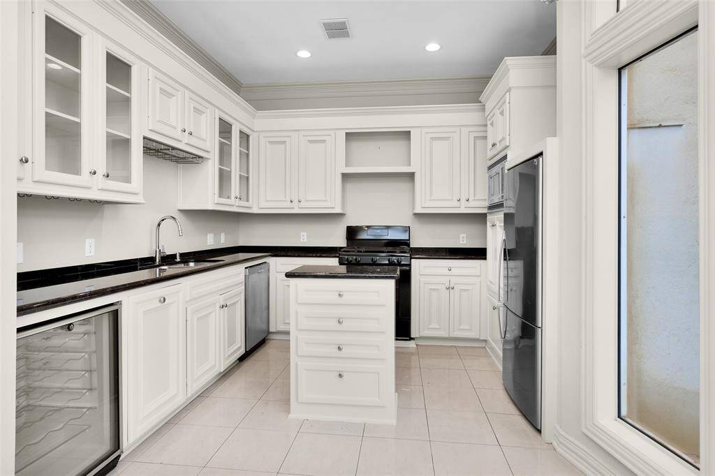 Island Kitchen with Granite Surfaces, Glass Front Cabinets, Wine Frig and Refigerator.