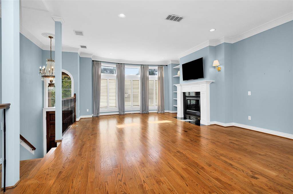 Den with Fireplace and Floor to Ceiling Windows with Plantation Shutters.