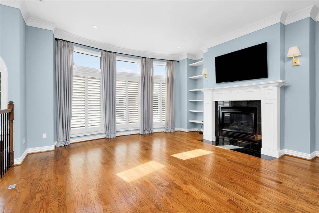 Den with Fireplace and Floor to Ceiling Windows with Plantation Shutters.