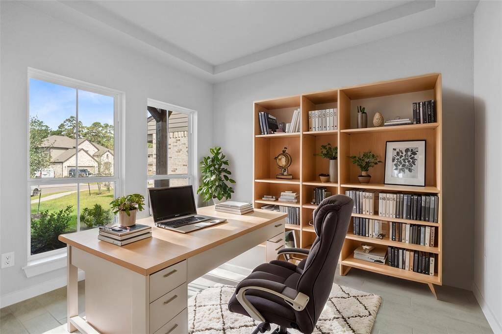 Nestled away quietly in the front of the home is the handsome home office! Featuring high ceilings, custom paint, large tile flooring, and large windows with privacy blinds!