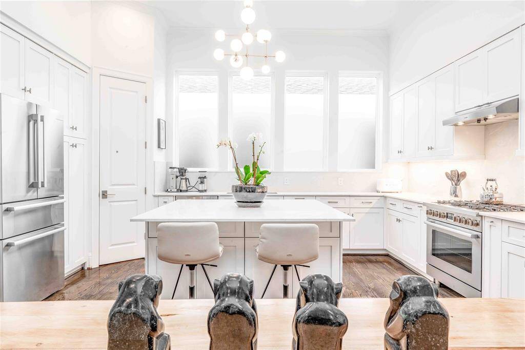 Experience seamless dining and culinary elegance with this open view from the dining room into the bright, modern kitchen.