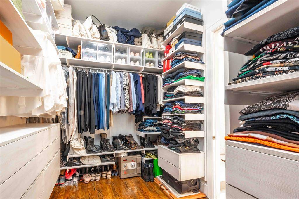 Walk-in primary closet is outfitted with custom built-ins