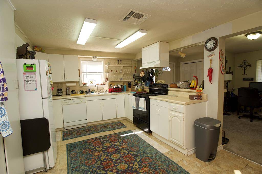 This kitchen features ample counter space and cabinetry with a cozy, lived-in feel.