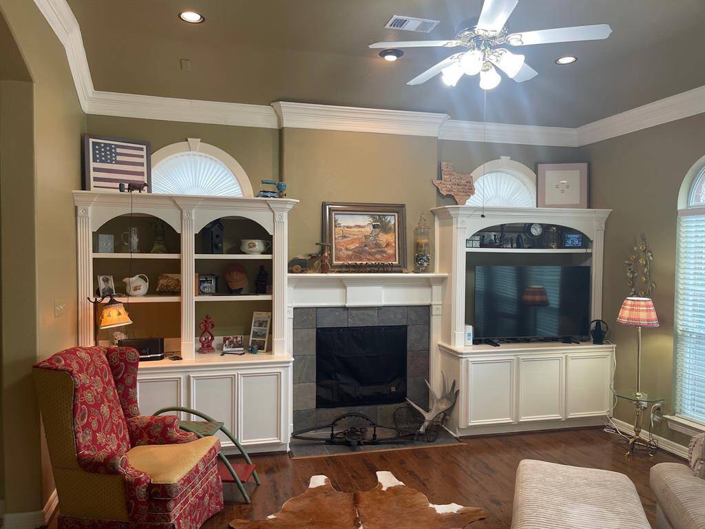 Lots of crown molding and windows providing natural light. Fireplace is surrounded by slate tile.