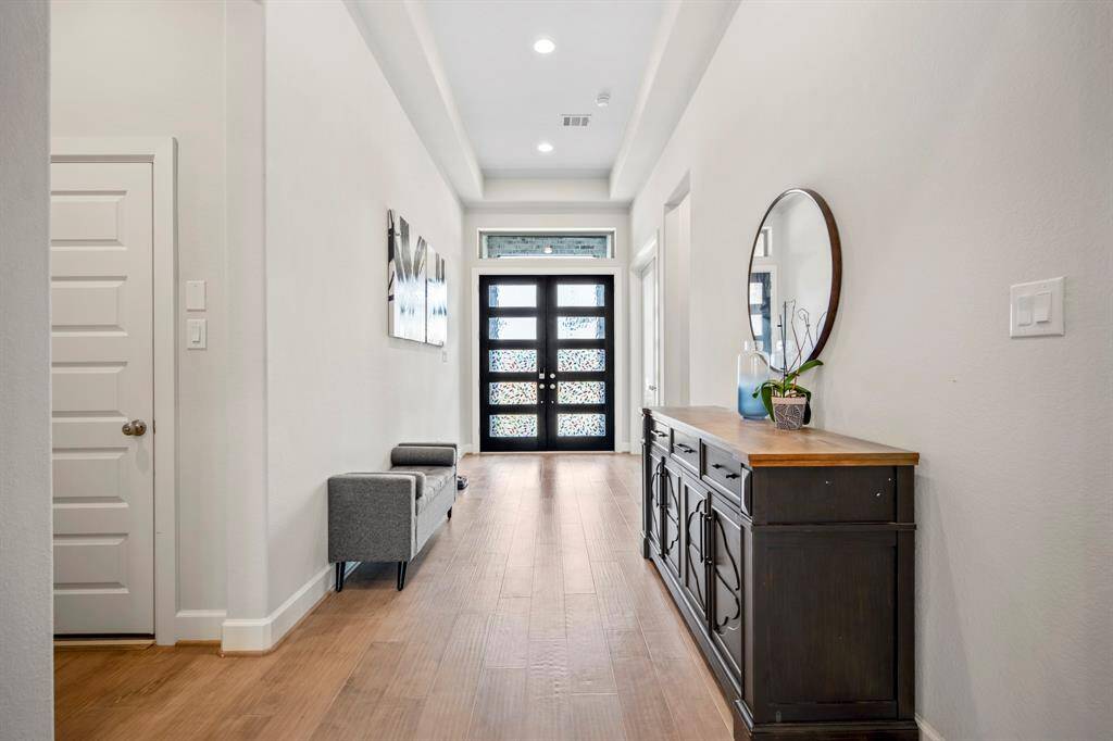 Heading back to the front of the home, you see another view of the open and large entry way, leading to the home office, game room, and secondary bedrooms.
