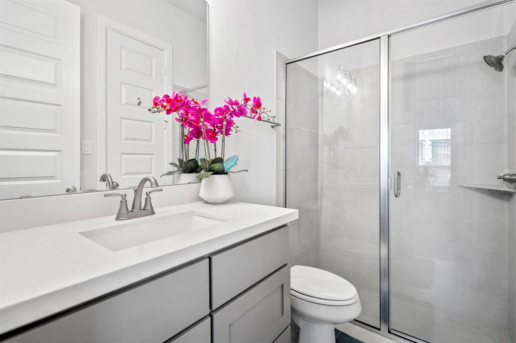 Relax and unwind in this beautifully designed secondary bathroom, featuring elegant quartz countertops and a large walk in shower for the ultimate in comfort and style.