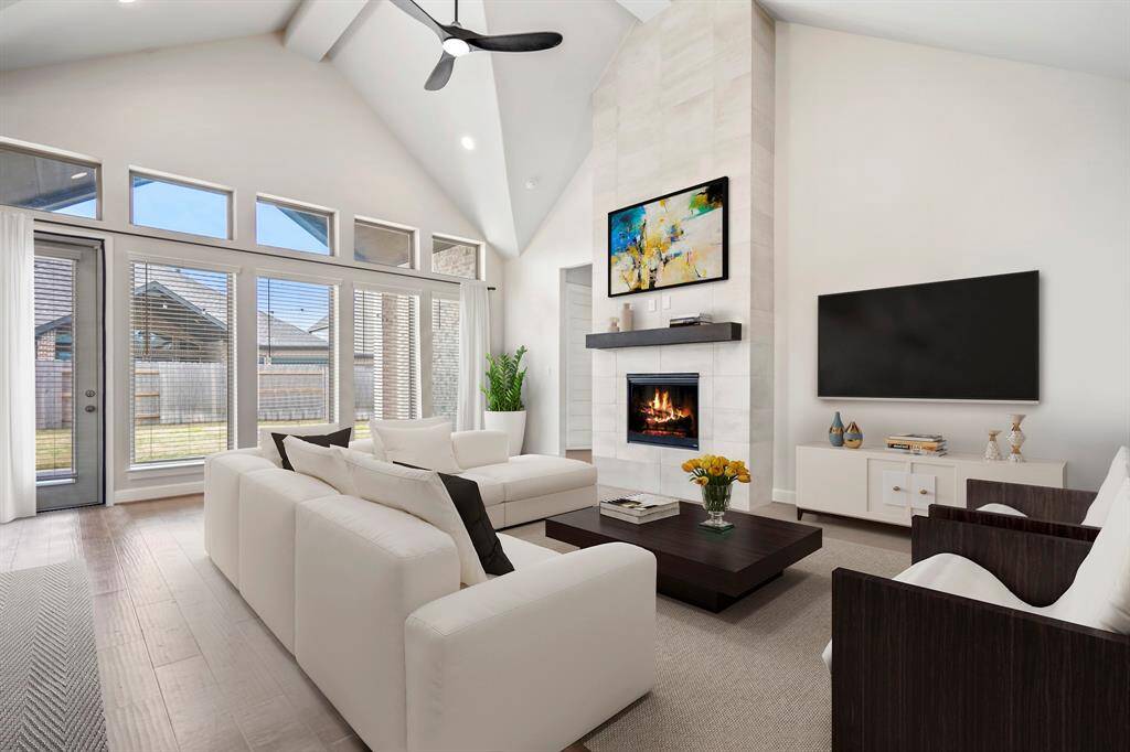 Gather the family and guests together in your huge living room! Featuring high ceilings, dark modern ceiling fan, and large windows that provide plenty of natural lighting throughout the day! You'll love cozying around the fireplace with the upgraded extended tile and sleek wood mantle. *This room has been virtually staged