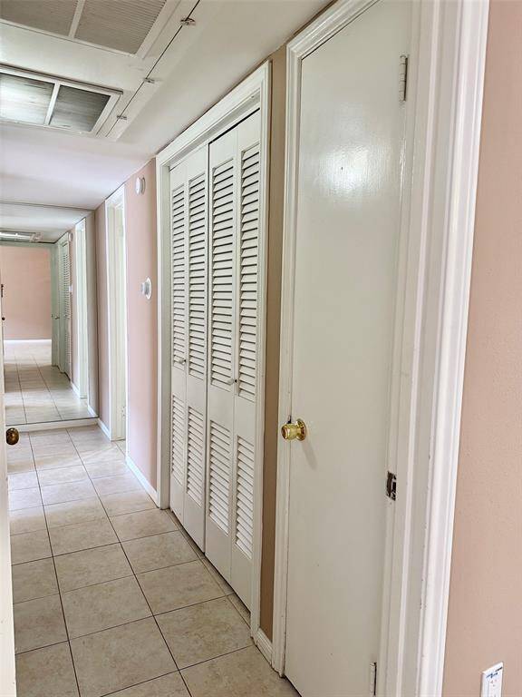 Hallway to bedrooms and baths. Closets are shown along the right. At the end of the hallway is a floor to ceiling mirror.