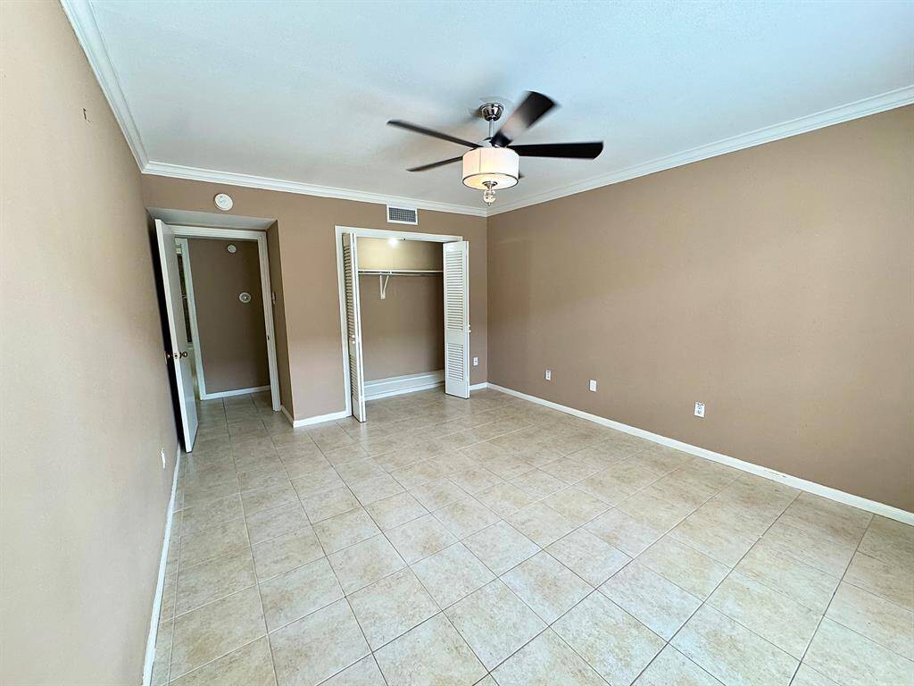 Ceiling fan and light fixture, crown molding and lighted closet with louvered bi-fold doors.  There is a shoe rack as well.