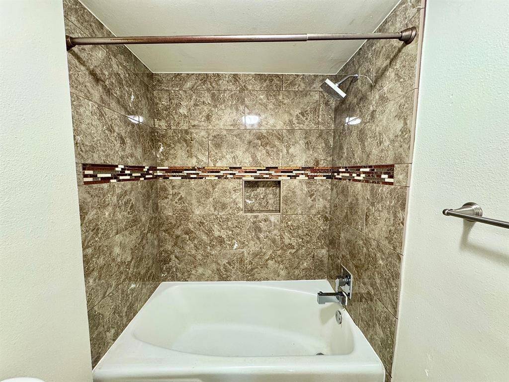 Hall bathtub tiled surround up to ceiling.