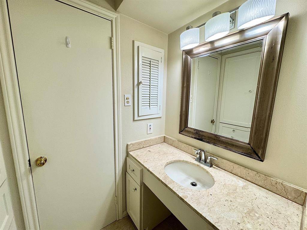Hall bath vanity with wall cabinet to left of mirror.