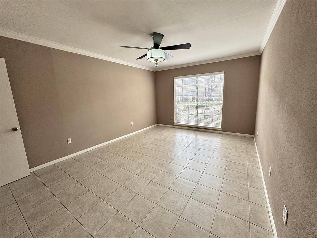 Primary bedroom also has a ceiling fan with light fixture and crown molding. It is slightly larger than secondary bedroom.