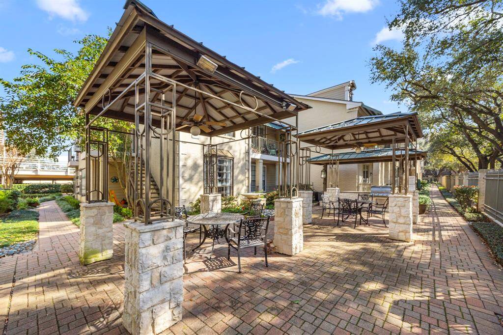 Spacious outdoor common area features elegant covered pergolas, stone-accented pillars, and ample seating, perfect for relaxing or entertaining.