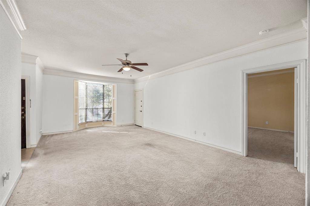 Spacious living room with large bay window. Plenty of natural lighting and a secondary exit into the private outdoor patio.