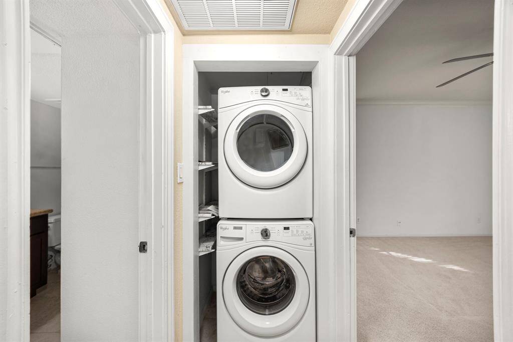 Stackable washer/dryer, conveniently located next to a bedroom.