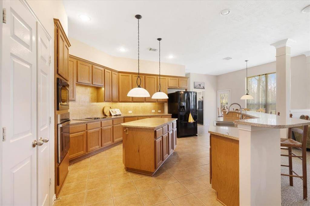 The large kitchen has a breakfast bar, large island with ample storage, cooktop, granite counters, recessed lighting as well as under mount lighting. Plenty of space for entertaining.