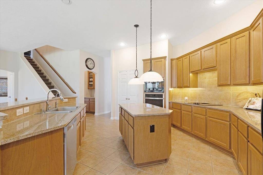 Another view of the kitchen as well as the butler pantry and stairs leading to the game room.