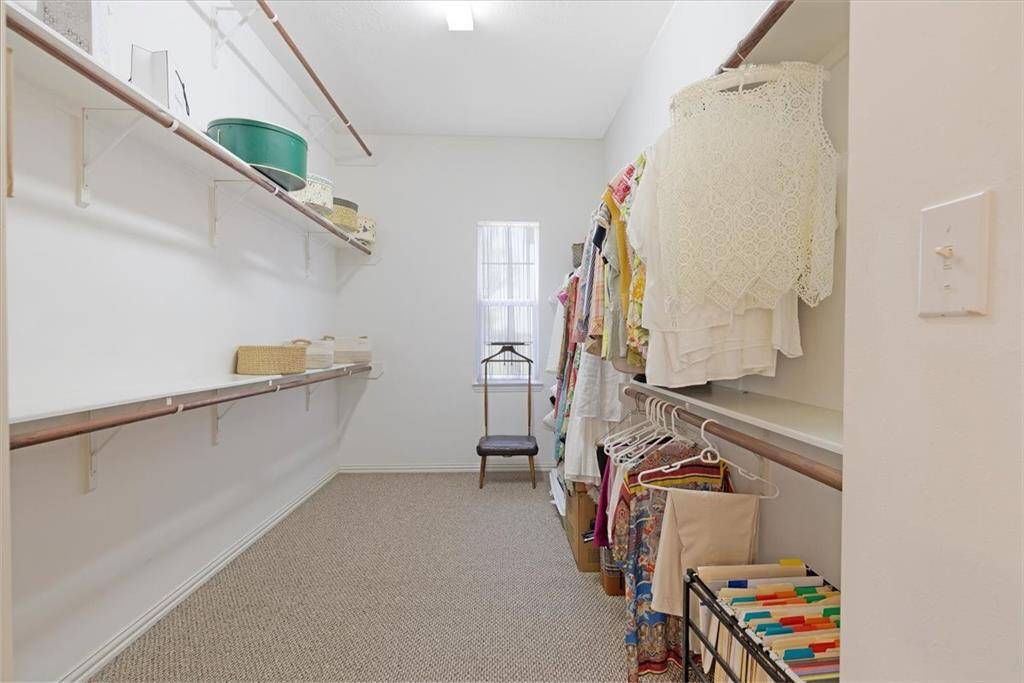 The primary bedroom closet has plenty of space for storage and natural light with the window.