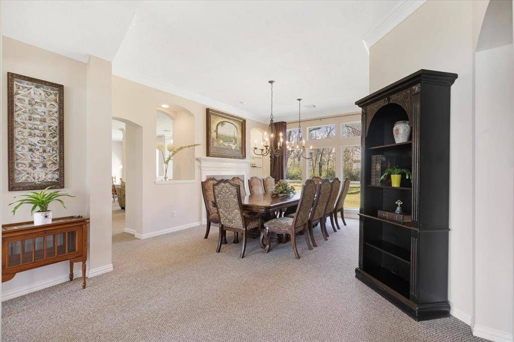 Formal dining room with fireplace and large windows facing the back of the property