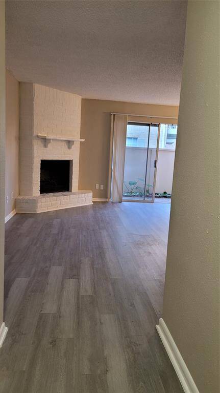 Fireplace in the living room next to a sliding window-door that leads to a nice small patio