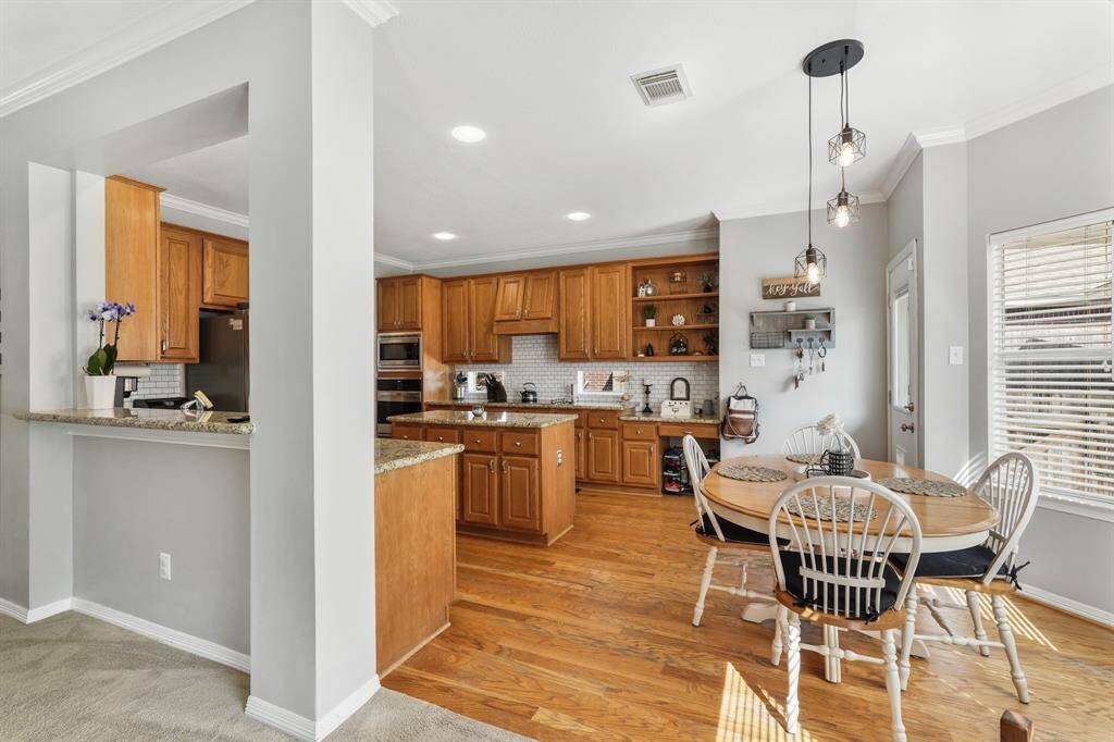 The breakfast nook, seamlessly connected to the kitchen, is warmly lit by recessed lighting and modern fixtures.