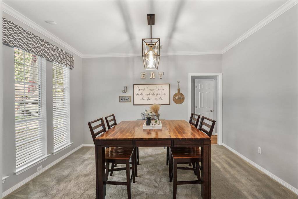 The formal dining room is sleek and beautiful. An abundance of natural light joins the intricate lighting to illuminate the room. This photo is staged for photo purpose.