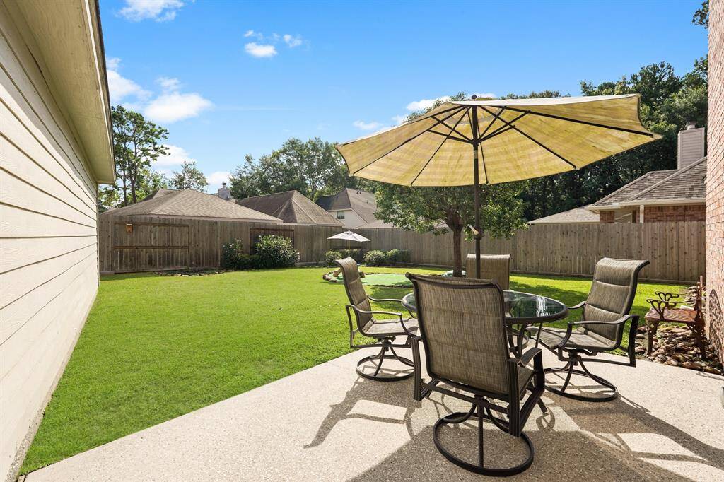 A charming patio overlooks a large backyard.