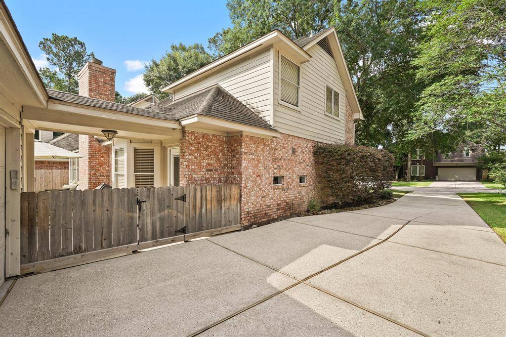 A long, private driveway leads to a detached 2-car garage. Notice the covered walkway connecting the garage to the back of the home.