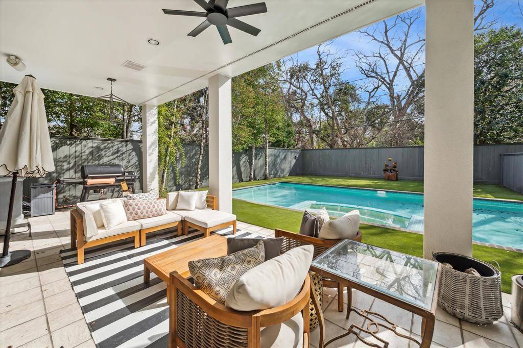 The family room and breakfast room overlook an expansive covered porch, offering a perfect outdoor retreat with ample seating and picturesque views of the pool and lush backyard.