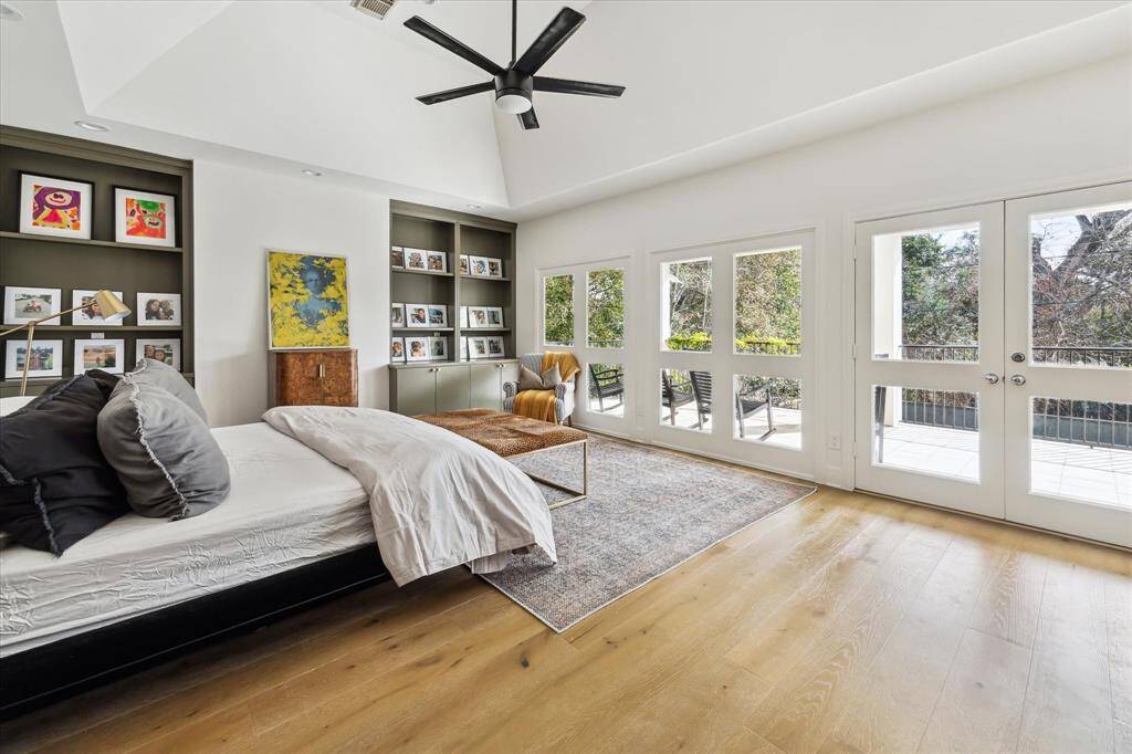 This serene primary suite boasts vaulted ceilings, custom built-ins, and an abundance of natural light. French doors open to a spacious private balcony, creating a seamless indoor-outdoor retreat.