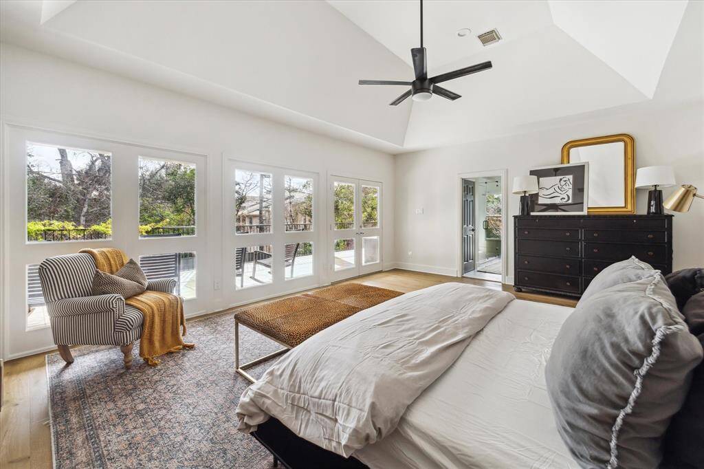 Luxury meets comfort in this airy primary suite, featuring soaring ceilings, custom built-ins, sleek hardwood floors, and access to your own private balcony overlooking the shimmering pool.