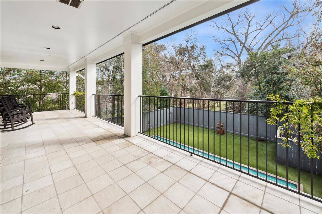 Enjoy tranquil views from this expansive, 400+ sq ft covered balcony off the primary suite, overlooking the lush backyard and pool. A perfect retreat for morning coffee or evening relaxation.