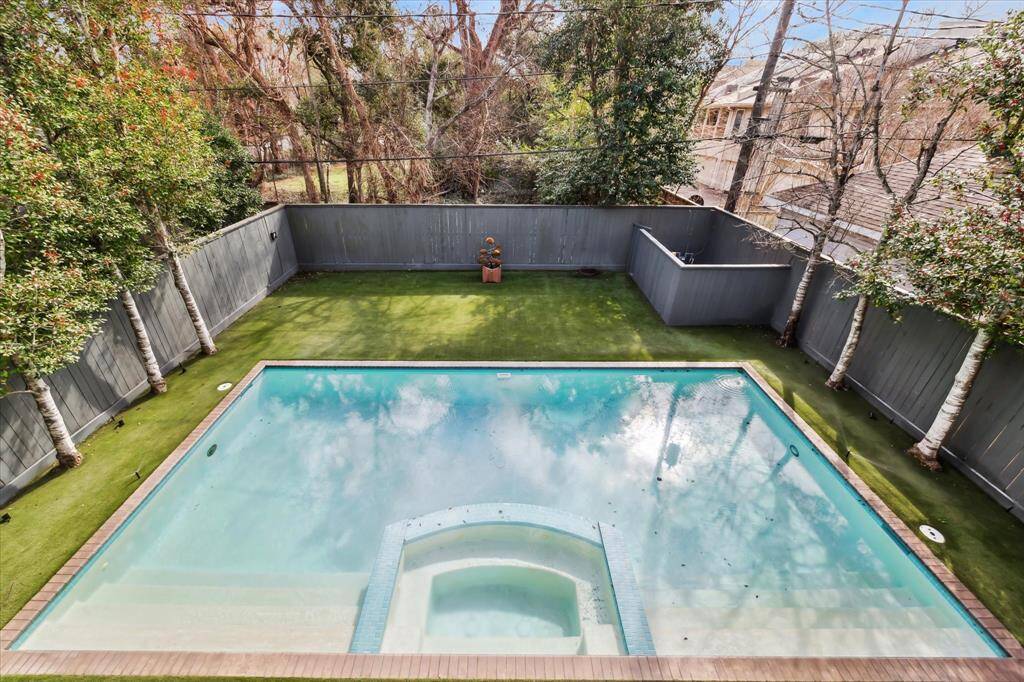 Overlooking the lush backyard, the balcony offers a breathtaking view of the sparkling pool and serene greenery, creating a private oasis for relaxation.