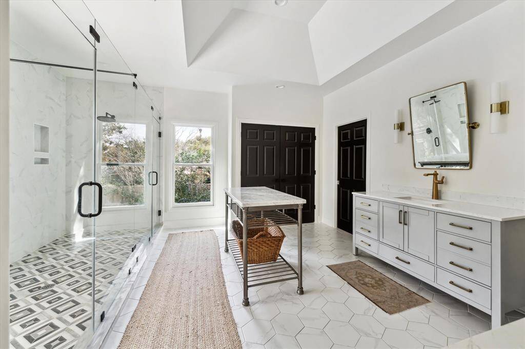 This spa-like primary ensuite features a stunning glass-enclosed shower, elegant quartz finishes, and designer fixtures, creating a serene retreat for relaxation.