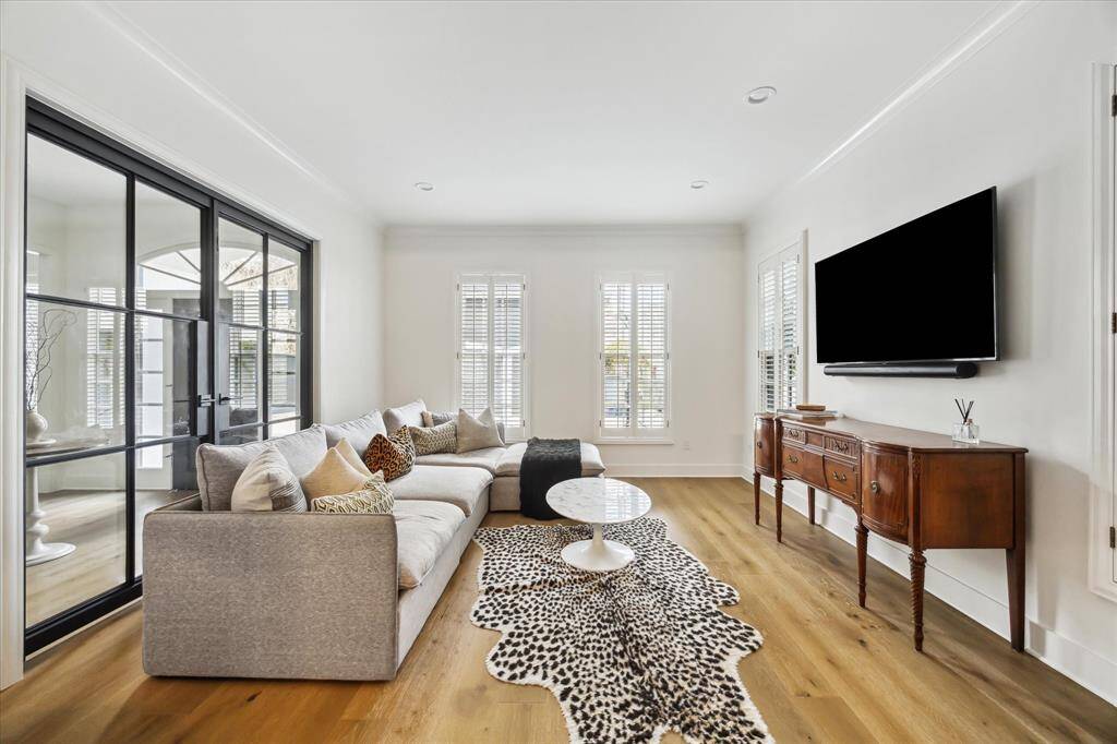 The cozy formal living room, located beyond sleek steel-framed doors, offers the perfect blend of privacy and openness. The versatile design allows the space to be closed off for intimate gatherings or left open to flow seamlessly with the rest of the home.