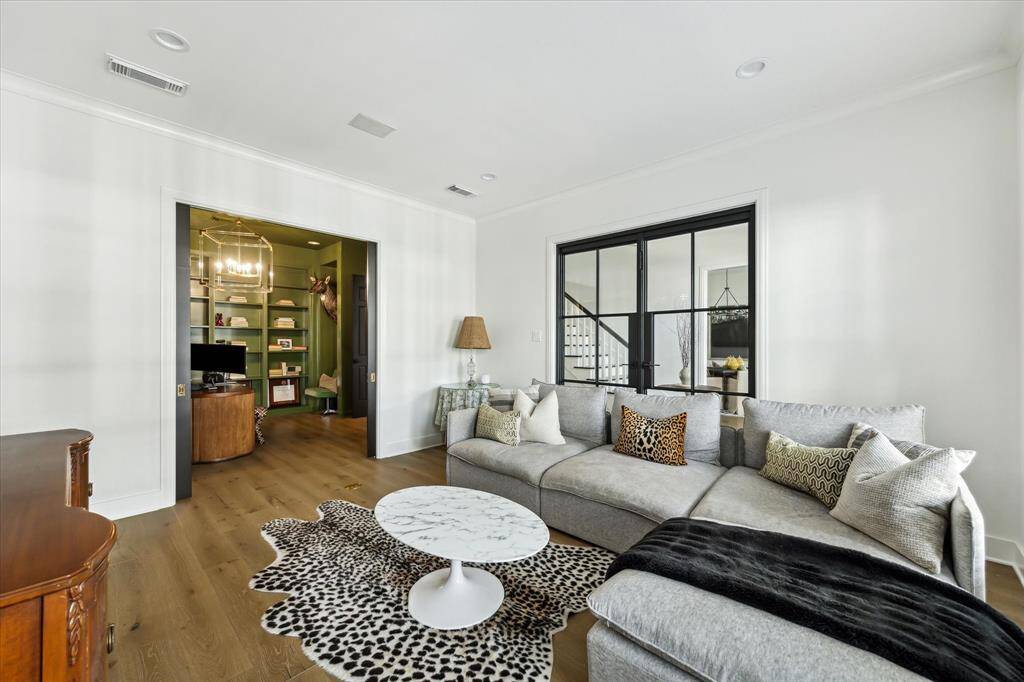 Connected by elegant pocket doors, the living room flows effortlessly into a private office or library, offering versatility and a harmonious layout for modern living.