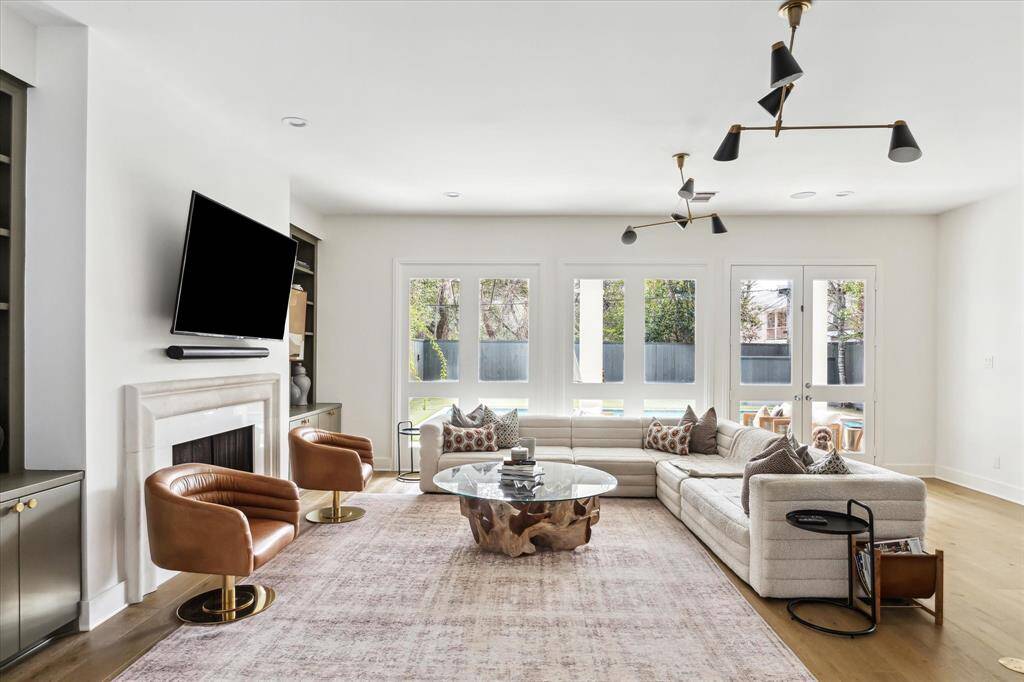 Expansive windows and French doors flood the family room with natural light while providing seamless access to the outdoor living area, creating an ideal space for entertaining or relaxing.