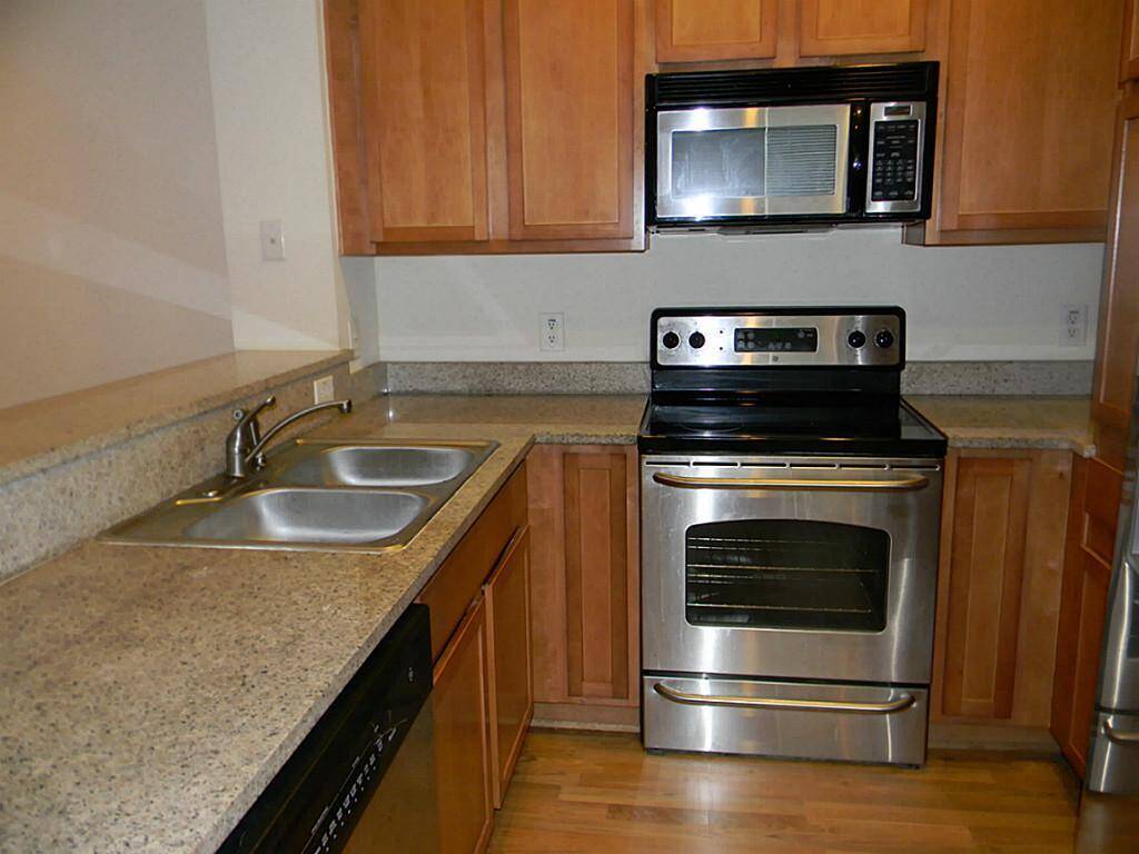 Kitchen w/granite counter tops and stainless steal appliances.