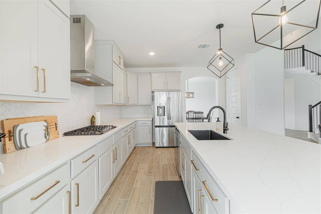 The kitchen also features stainless steel appliances, gas cooktop and tile backsplash.