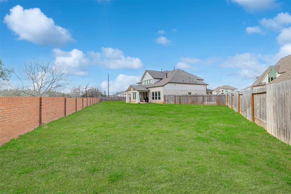The expansive backyard is pool-ready, complete with a covered patio—perfect for entertaining!