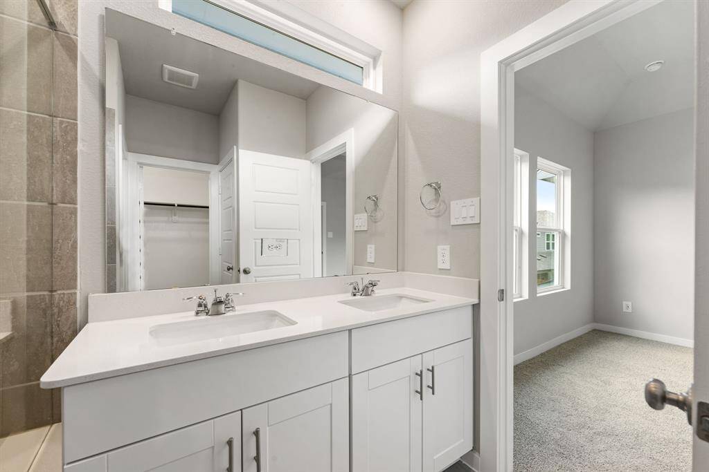 A closer look at the double vanity reveals ample counter space, storage, and convenient access to the adjoining closet.