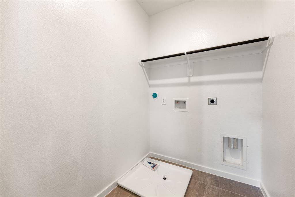 Dedicated laundry room with full-size washer/dryer connections, a built-in shelf for added storage, and a convenient drain pan for easy maintenance.