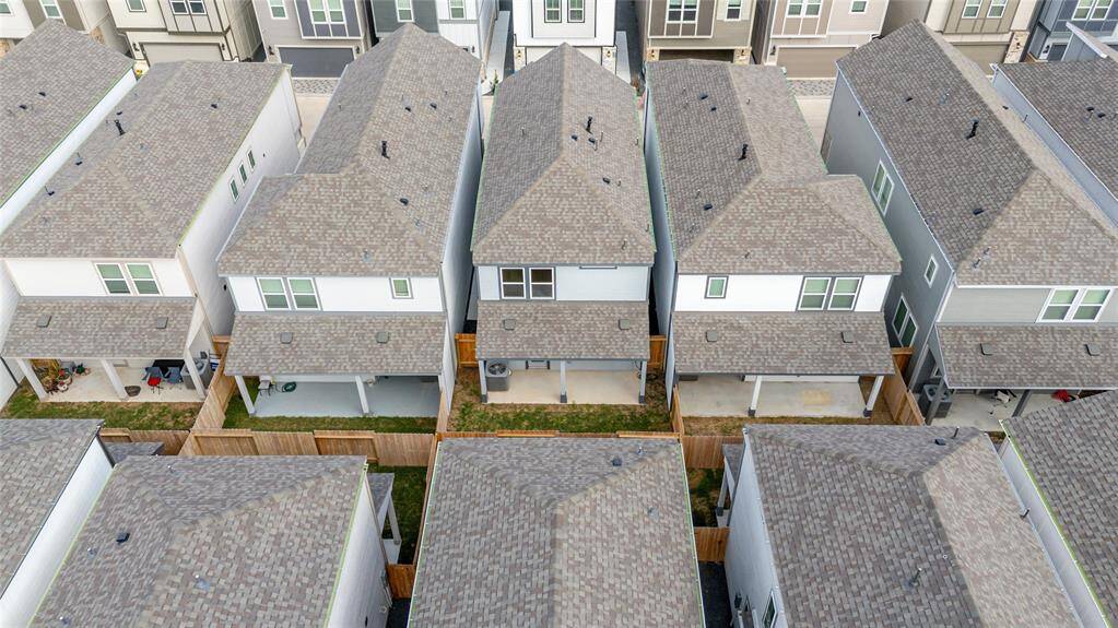 A bird’s-eye view highlights the home’s covered patio and fenced yard, nestled neatly among neighboring properties.