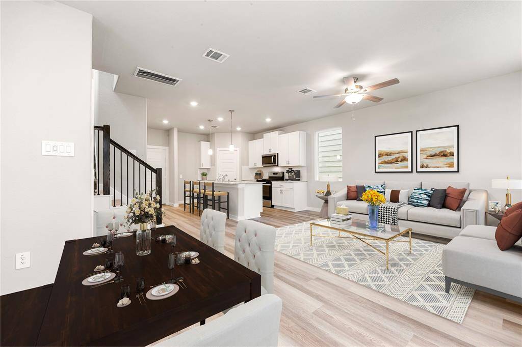This light and bright spacious living room is the perfect layout for entertaining or just relaxing. Whether it's simply a night in or entertaining family and friends, this home has ample open space for everyone to enjoy! Featuring dark stained ceiling fan, wood style flooring, large windows with blinds, soaring high ceilings, recessed lighting with wonderful access to your gorgeous kitchen. *Virtually Staged