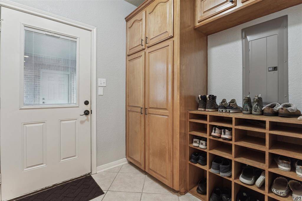 Enter through the side door into the mudroom with closet and shoe organization space.