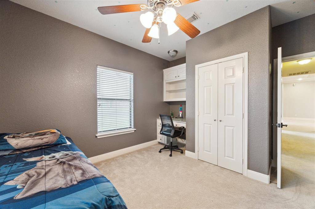 One of 3 secondary bedrooms with built-in desk and shelving.