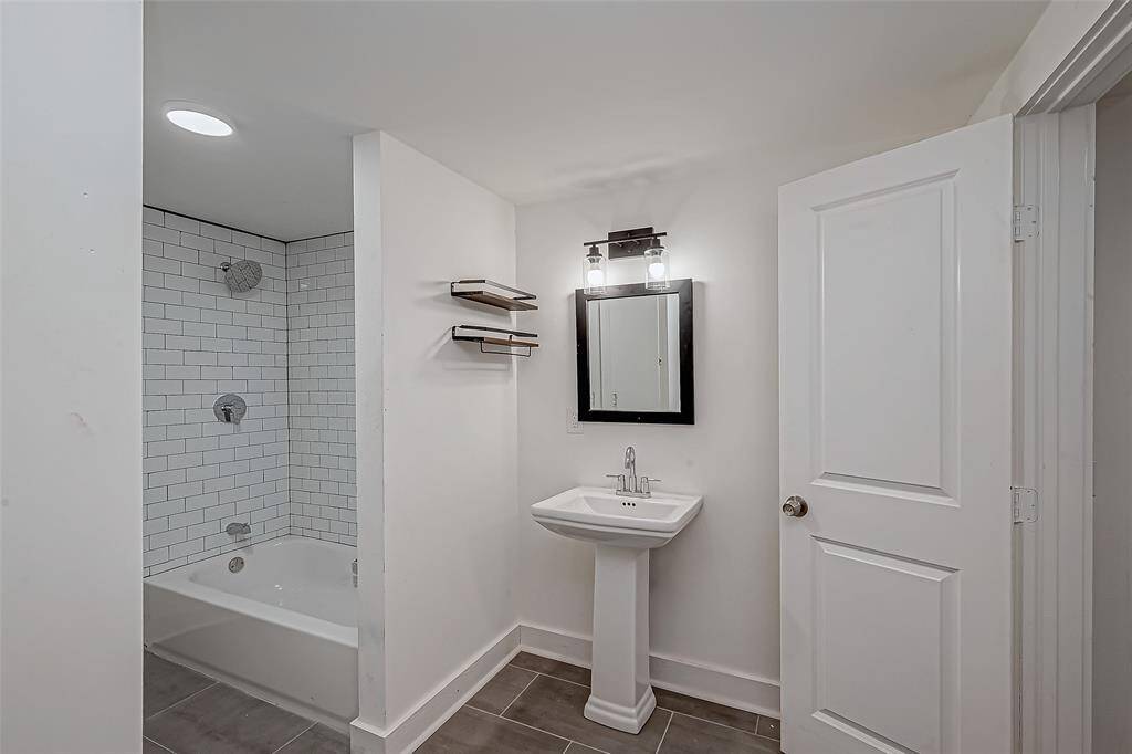 Simplicity meets function in the en suite bath, where a shower/tub combo offers versatility. The white walls and fixtures keep the space bright.
