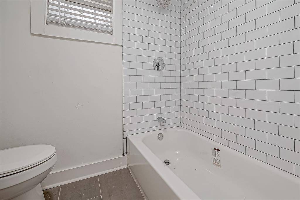 The soft lighting in this bathroom complements the clean aesthetic, while the tub/shower combination ensures practicality without sacrificing style.
