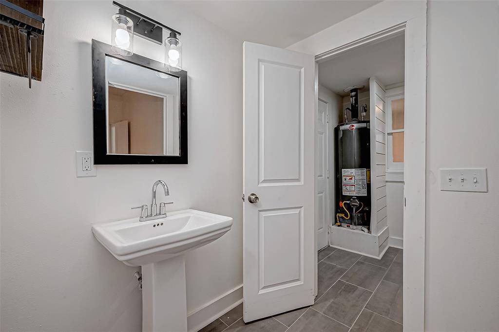 Clean and well-lit, this en suite bathroom keeps things simple with a bright white palette and essential features. The vanity area is especially striking with stylish lighting.